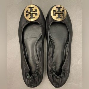 Tory Burch black leather ballet flats with signature gold logo design on the toe